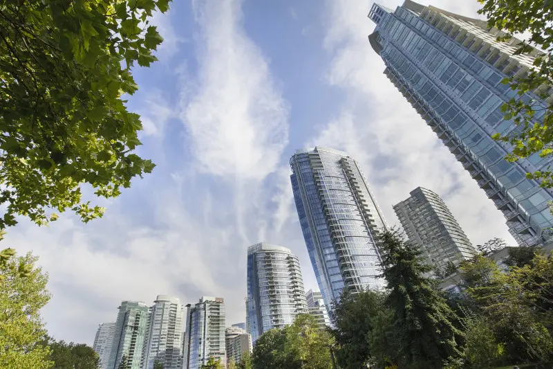 A group of tall buildings and trees in a park.
